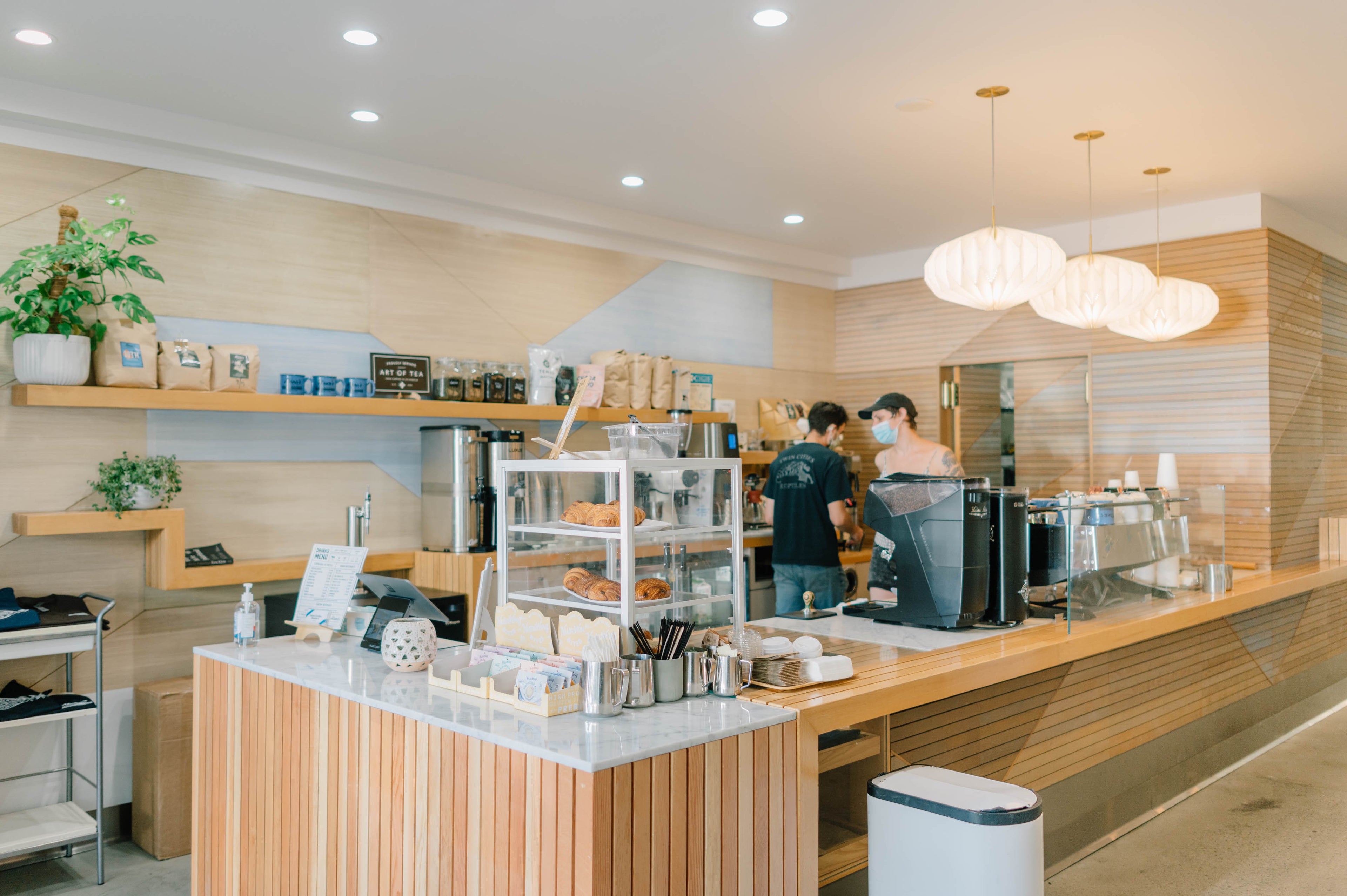 The interior of Alana's in West Hollywood. Two men work behind the pale wooden counter.