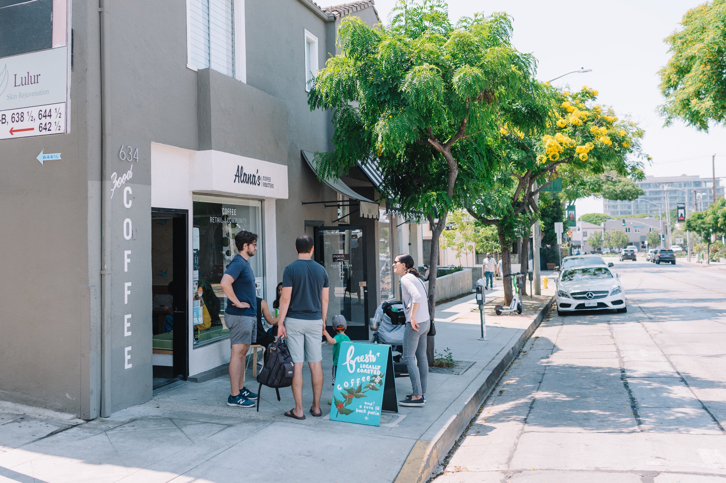 Three people stand outside the storefront of Alana's Coffee Roasters in West Hollywood.