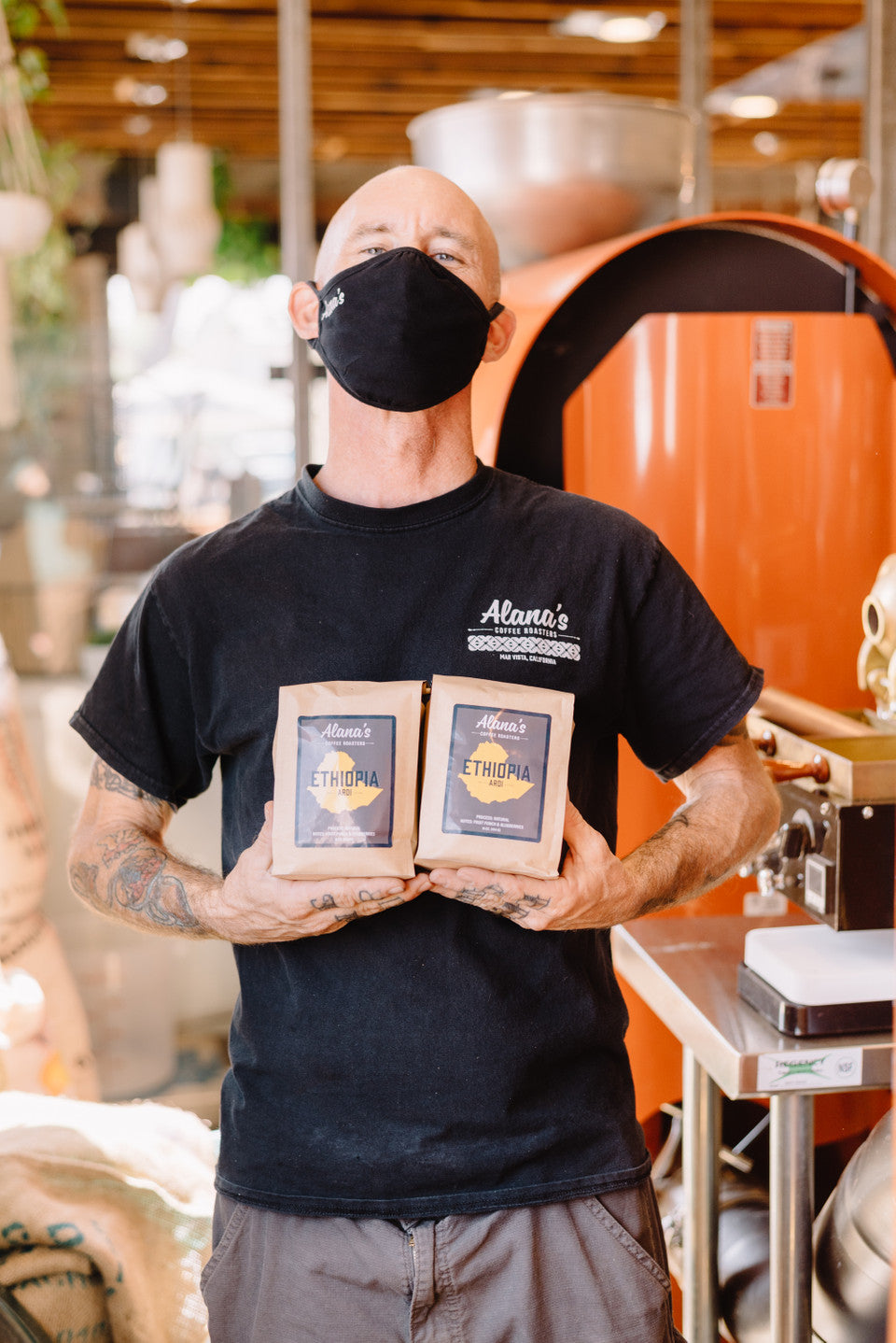 A man holds two bags of Ethiopian ardi coffee.